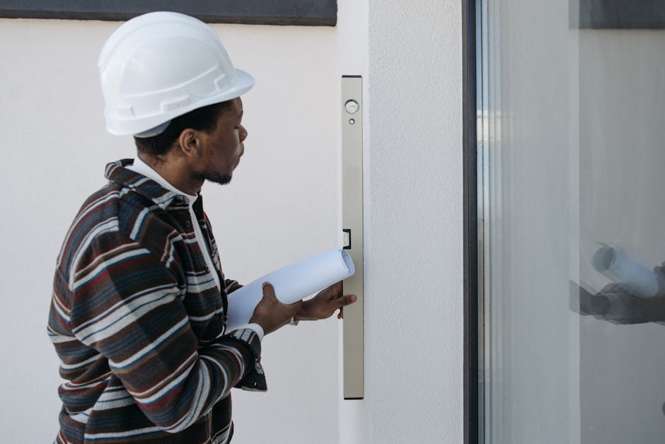Architect using a level for construction checks, wearing safety helmet.
